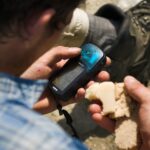 Person hält ein Garmin-GPS-Gerät in der Hand und schaut auf das Display