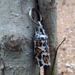 Kleiner Micro-Geocache hängt versteckt an einem Baumstamm